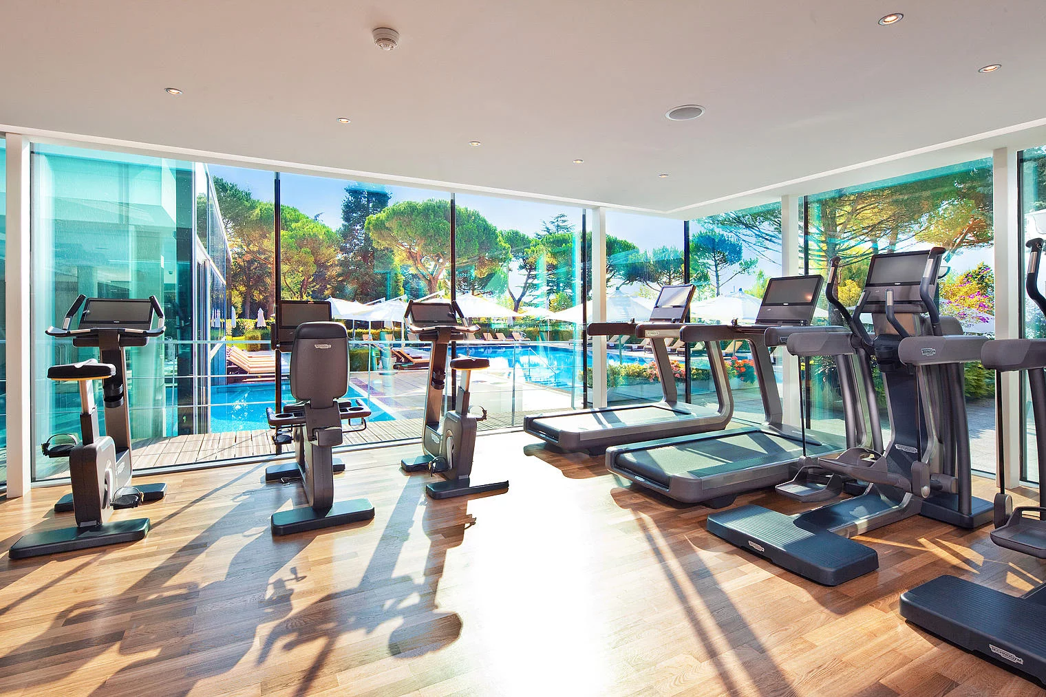 Espace fitness ouvert sur la piscine et les jardins